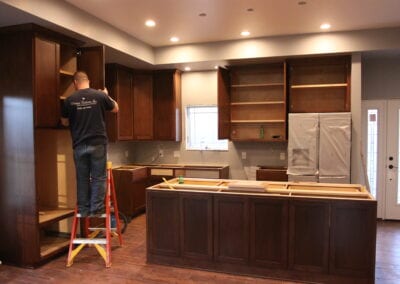 man putting together cabinets in a kitchen
