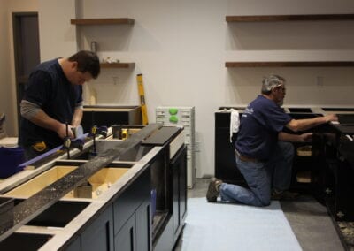men working in a kitchen putting together cabinets